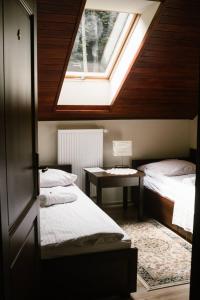a bedroom with two beds and a skylight at Willa Zacisze - Apartament dwupoziomowy in Kalwaria Zebrzydowska