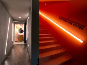 Un escalier avec un mur rouge et un escalier lumineux dans l'établissement Demo Hotel Design Emotion, à Rimini