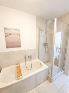 a bathroom with a shower and a tub and a sink at PB Ferienwohnungen - FeWo 7 - Stilvoll eingerichtetes Apartment im Herzen Senftenbergs in Senftenberg