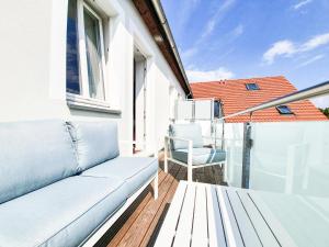 a porch with a couch and a chair on a balcony at PB Ferienwohnungen - FeWo 7 - Stilvoll eingerichtetes Apartment im Herzen Senftenbergs in Senftenberg