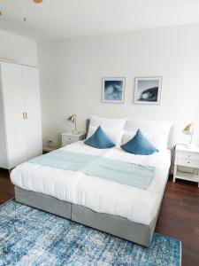 a bedroom with a large bed with blue pillows at PB Ferienwohnungen - FeWo 7 - Stilvoll eingerichtetes Apartment im Herzen Senftenbergs in Senftenberg