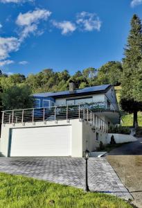 een huis met een grote witte garage en een balkon bij Ferienwohnung Talblick in Schönau im Schwarzwald