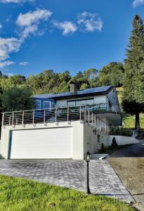 ein Haus mit einer großen weißen Garage mit Balkon in der Unterkunft Ferienwohnung Talblick in Schönau im Schwarzwald
