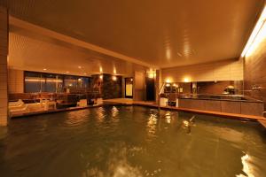 a large swimming pool in a hotel with a kitchen at Shiga Park Hotel in Yamanouchi