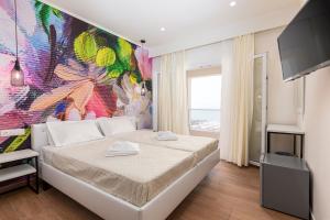 a bedroom with a large colorful painting on the wall at Aqua Luxury Suites by Estia in Roda