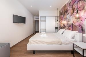 a bedroom with a bed and a tv on a wall at Aqua Luxury Suites by Estia in Roda