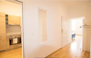 a room with a white wall and a kitchen at Gelassener Aufenthalt l LF9 in Vienna