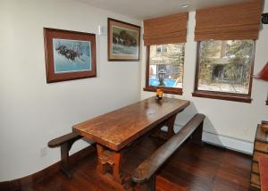 une salle à manger avec une table en bois et un banc dans l'établissement Lionshead Center #201 Condo, à Vail