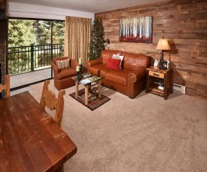 a living room with a leather couch and a table at Vantage Point #209 Condo in Vail