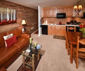 a living room with a couch and a table and a kitchen at Vantage Point #209 Condo in Vail