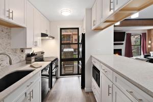 a kitchen with white cabinets and white counter tops at Breakaway West #212 condo in Vail