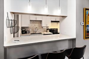 a kitchen with white cabinets and black chairs at Breakaway West #212 condo in Vail