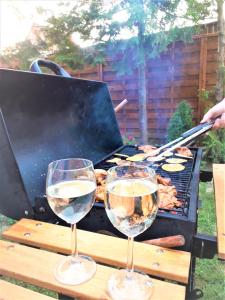 two glasses of white wine sitting on a grill at Napocska Vendégház Harkány in Harkány