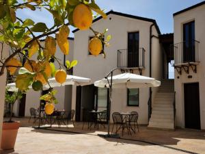 un patio al aire libre con sillas, mesas y sombrillas en B&B Le Cale, en Santa Maria Navarrese