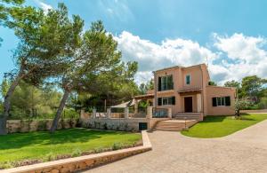 an exterior view of a house with a yard at Villa Cala Mesquida in Cala Mesquida