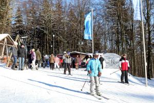 eine Gruppe von Menschen auf Skiern im Schnee neben einer blauen Flagge in der Unterkunft Ferienwohnung-Jung in Bad Sachsa