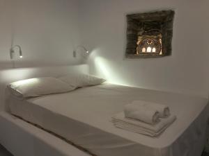 a white bed with two towels and a fireplace at Villa Meltemi in Arnados