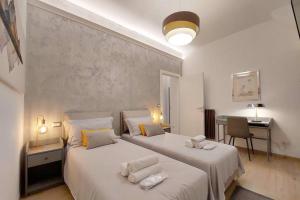 1 Schlafzimmer mit 2 Betten, einem Tisch und einem Schreibtisch in der Unterkunft Aventino Contemporary Apartment in Rom