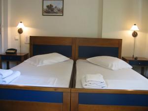 two beds in a room with towels on them at Aiolos in Loutra Edipsou +16 photos