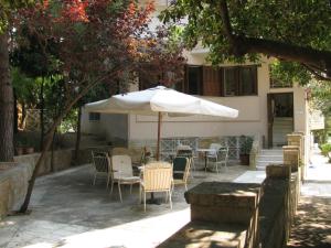 a table and chairs with an umbrella in front of a house at Aiolos in Loutra Edipsou