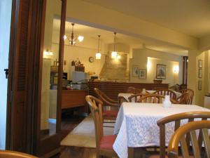 a dining room with tables and chairs and a kitchen at Aiolos in Loutra Edipsou