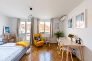 a bedroom with a bed and a table and a dining room at BRIGHT CHARMING Apt with TERRACE, PARKING & AirCo. in Prague