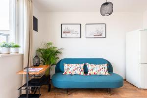 a blue couch in a living room with a table at BRIGHT CHARMING Apt with TERRACE, PARKING & AirCo. in Prague