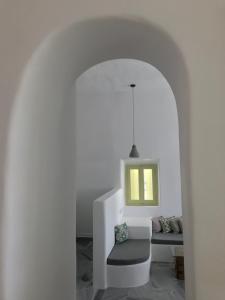 a white room with a chair and a bench at Villa Meltemi in Arnados
