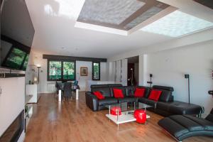 uma sala de estar com um sofá preto e almofadas vermelhas em Club Villamar - Piamonte em Calonge