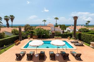 an image of a swimming pool with chairs and umbrellas at Villa Varadero by Escape Home in Alaior