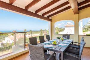 a dining room with a table and chairs with a view of the ocean at Villa Varadero by Escape Home in Alaior