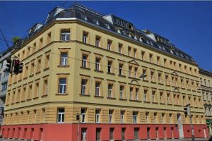 um grande edifício amarelo na esquina de uma rua em Studio-Apartment between Schoenbrunn & the City Center (13) em Viena