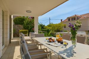 a table with a vase of flowers on a patio at Hedera Estate, Villa Hedera III in Zaton