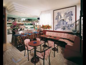 um restaurante com mesas e cadeiras e um bar em Hotel Emma Nord em Rimini