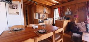 uma cozinha com uma mesa de madeira num quarto em Résid. La Bruyère 18 em Champoussin