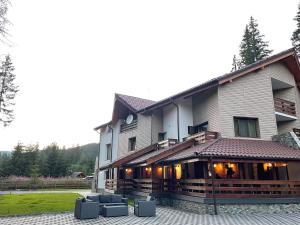 a large building with couches in front of it at Sidharta Resort in Obarsia-Lotrului