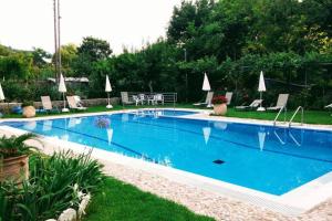 een groot zwembad met blauw water in een tuin bij Katerinas House Apartment in Agios Gordios