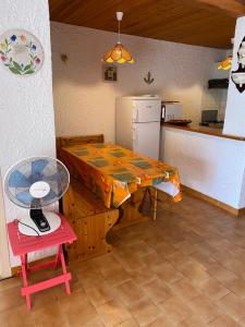 eine Küche mit einem Tisch und eine Küche mit einem Kühlschrank in der Unterkunft Location 5 personnes Sant Ambroggio Cocody village in Lumio