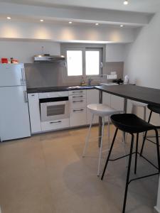 カラミにあるVilla Elsi upper apartmentの白い家電製品とテーブルと椅子を備えたキッチン +20枚の写真