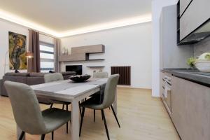 uma cozinha e sala de jantar com mesa e cadeiras em Aventino Contemporary Apartment em Roma