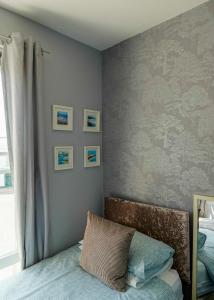 a bedroom with a bed and pictures on the wall at Southville Guest House in Weymouth