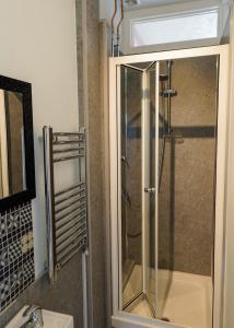 y baño con ducha y puerta de cristal. en Southville Guest House en Weymouth