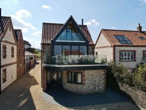 a house with a large glass window on top of it at The Breakers in Brancaster