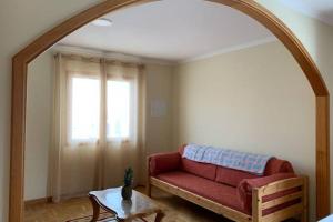 ein Wohnzimmer mit einem roten Sofa und einem Tisch in der Unterkunft Casa Da Villa in Vila Praia de Âncora