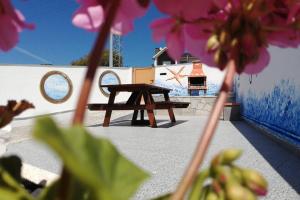 einem Picknicktisch vor einer Wand mit rosa Blumen in der Unterkunft Casa Da Villa in Vila Praia de Âncora