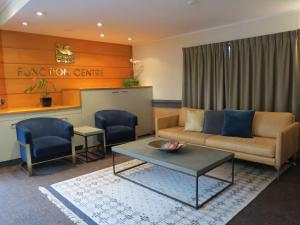 a living room filled with furniture and a table at Quality Hotel Lincoln Green in Auckland