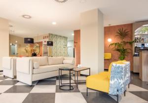 a living room with a white couch and a yellow chair at Soho Boutique Córdoba in Córdoba