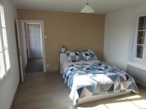 1 dormitorio con 1 cama con edredón azul y blanco en Gîte indépendant de 40 mètres carré pour les amoureux de la nature en Saint-Cyprien