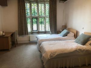 a hotel room with two beds and a window at Whalley Abbey - Christian Retreat House offering B&B in Whalley