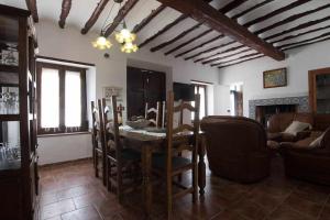 ein Wohnzimmer mit Tisch und Stühlen und einer Couch in der Unterkunft Casa Rural Patitas Caravaca in Caravaca de la Cruz
